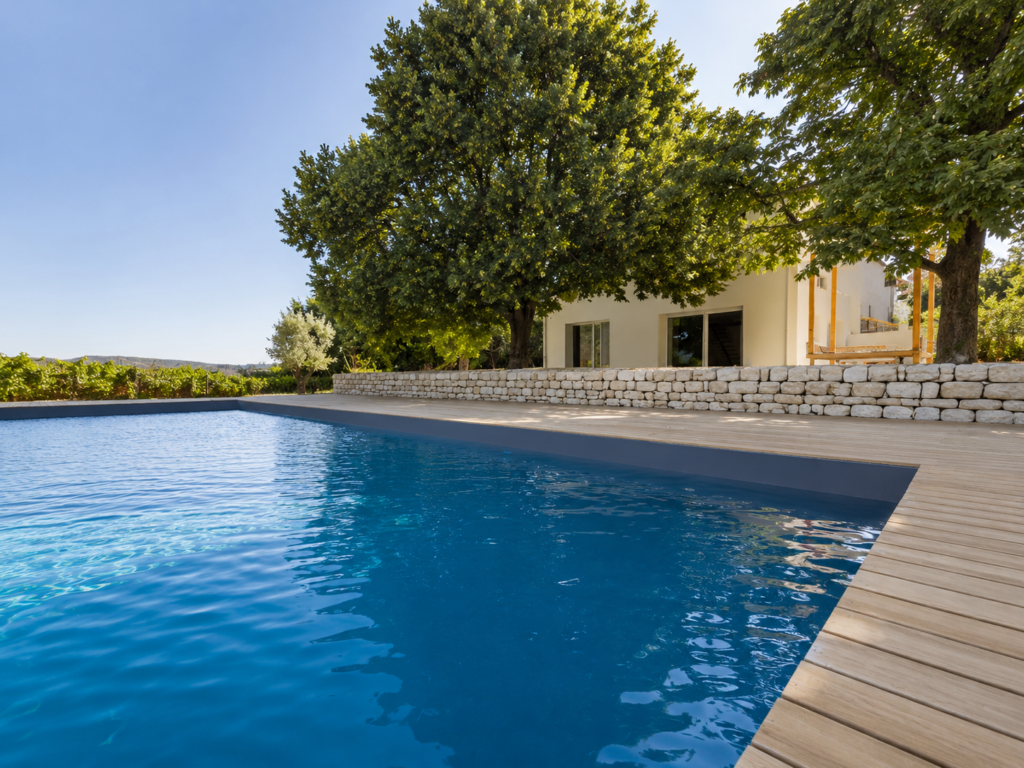 Maison rénovée à Puyricard avec nouvelle façade contemporaine, piscine, terrasse en bois et aménagement paysager réalisé après les travaux.