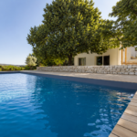 Maison rénovée à Puyricard avec nouvelle façade contemporaine, piscine, terrasse en bois et aménagement paysager réalisé après les travaux.