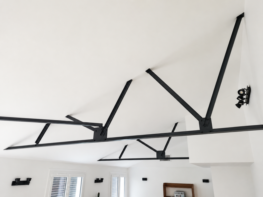 Charpente métallique apparente sous toit cathédrale après suppression du faux plafond dans une maison en kit rénovée à Châteauneuf-les-Martigues.